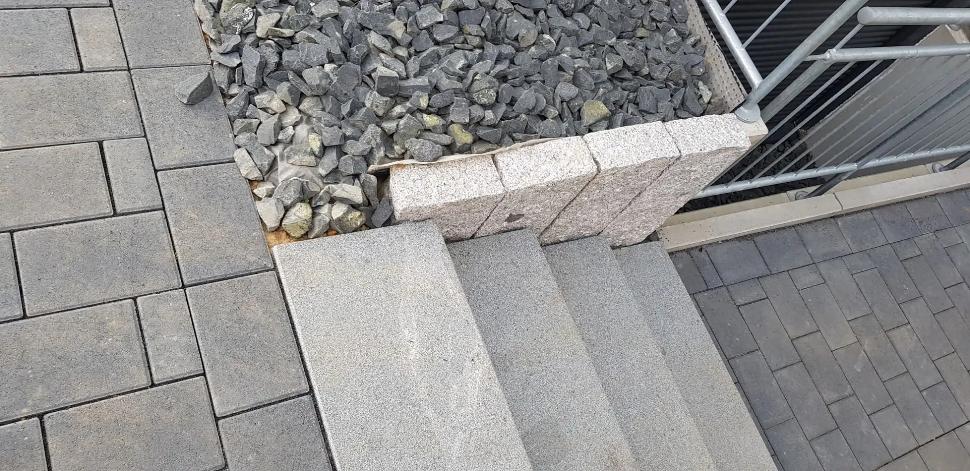 Detail: Stufen, Schotter in einer Steinkante und Pflaster
