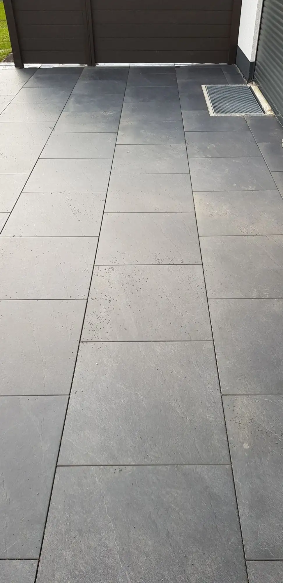 Dunkle Großformatplatten unter einer Terrassenüberdachung